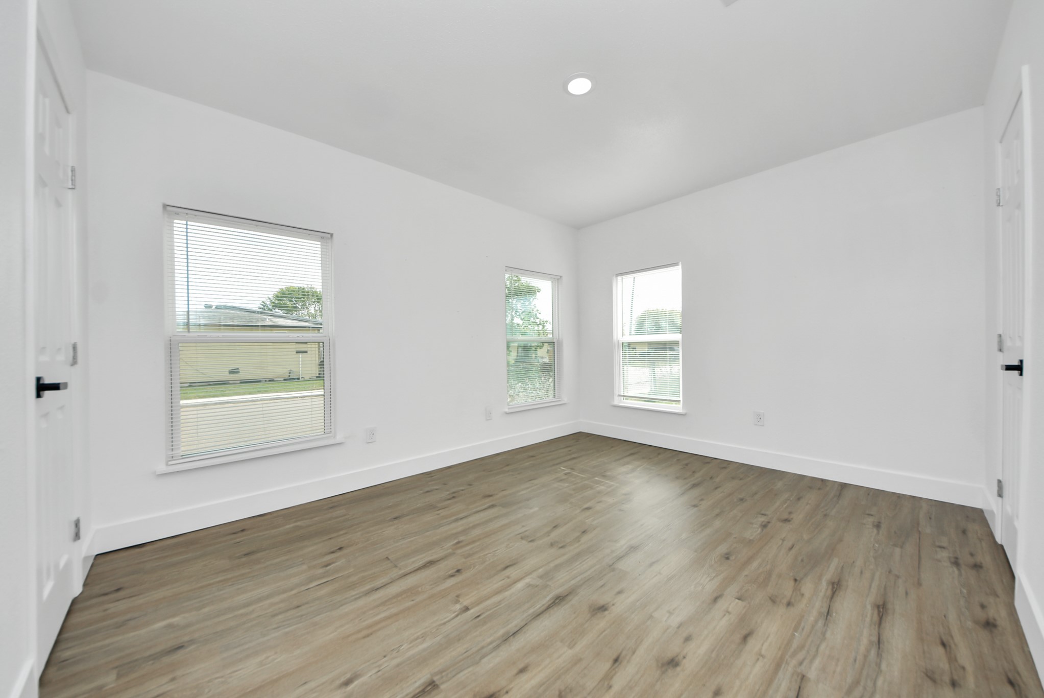 1203 West 6th Street Freeport, TX 77541 - Photo 43 of 50 an empty room with wooden floor and windows