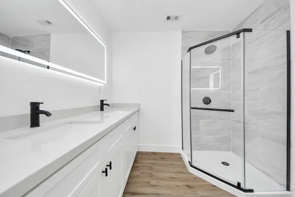a bathroom with a shower sink and mirror