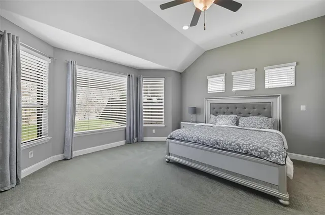 a spacious bedroom with a bed and a chandelier