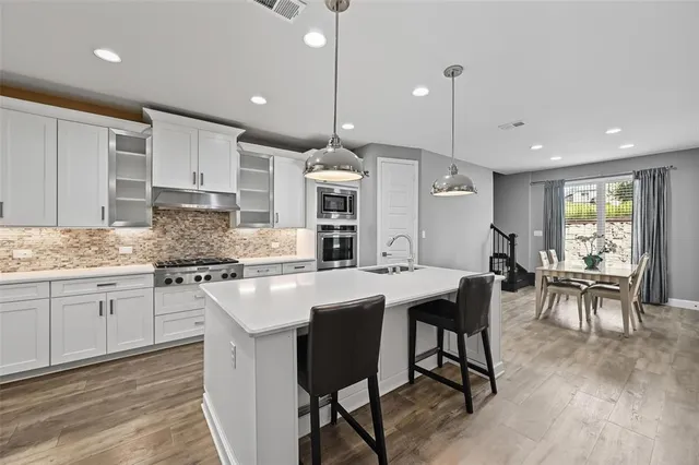 a large kitchen with kitchen island a dining table and chairs