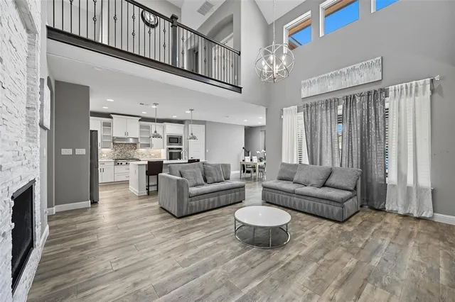 a living room with furniture kitchen view and a chandelier