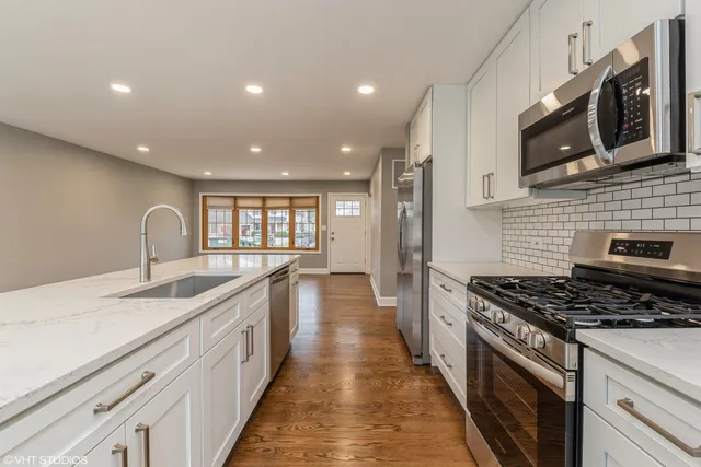 a kitchen with stainless steel appliances granite countertop a sink stove and microwave