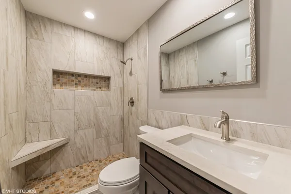 a bathroom with a sink a toilet and shower