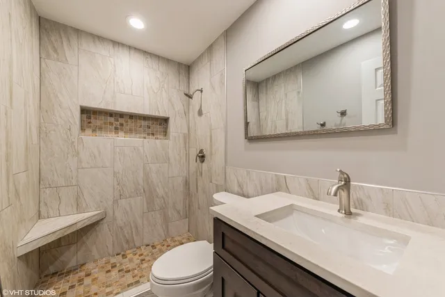 a bathroom with a sink a toilet and shower