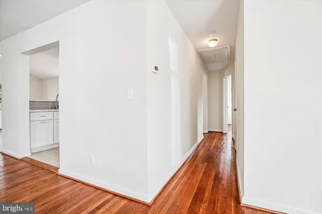a view of a hallway with wooden floor and entryway