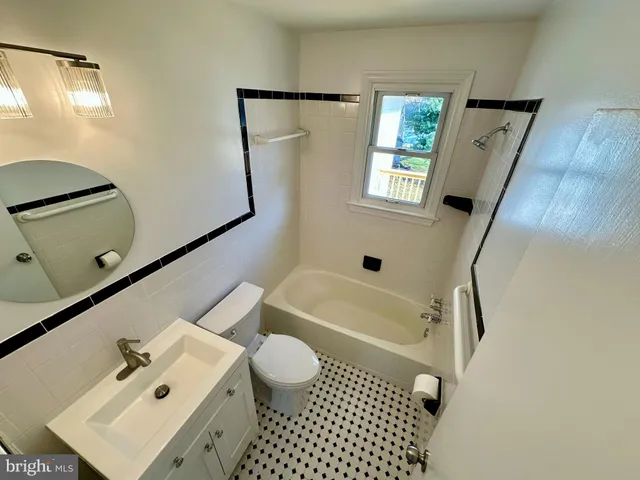 a bathroom with a bathtub shower sink vanity and toilet