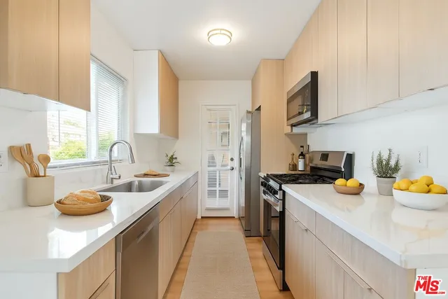 a kitchen with stainless steel appliances a sink stove and cabinets
