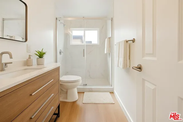 a bathroom with a sink a toilet and shower