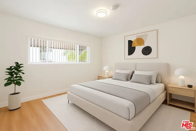 a bedroom with a bed and a potted plant