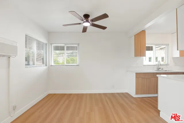 a view of empty room with wooden floor and window