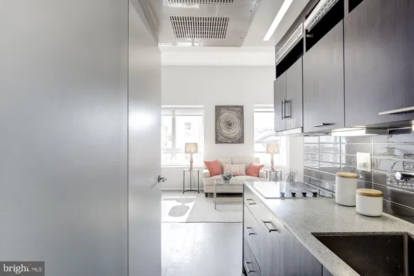 a kitchen with stainless steel appliances a refrigerator a sink a stove and white cabinets