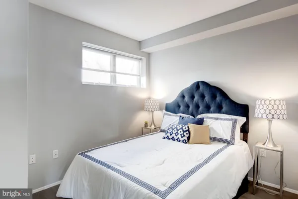 a bed sitting in a bedroom next to a window with lamp