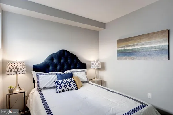 a bedroom with a bed and a painting on the wall