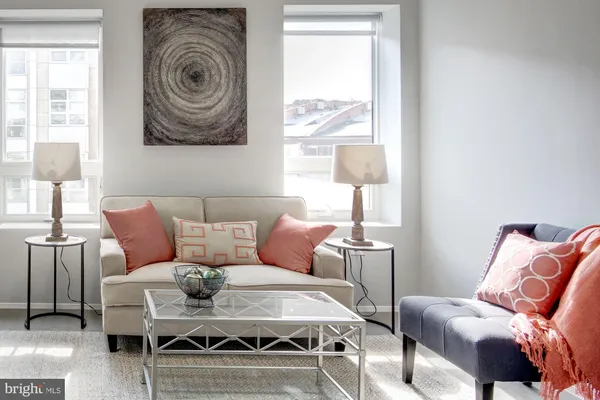 a living room with furniture a rug and a window