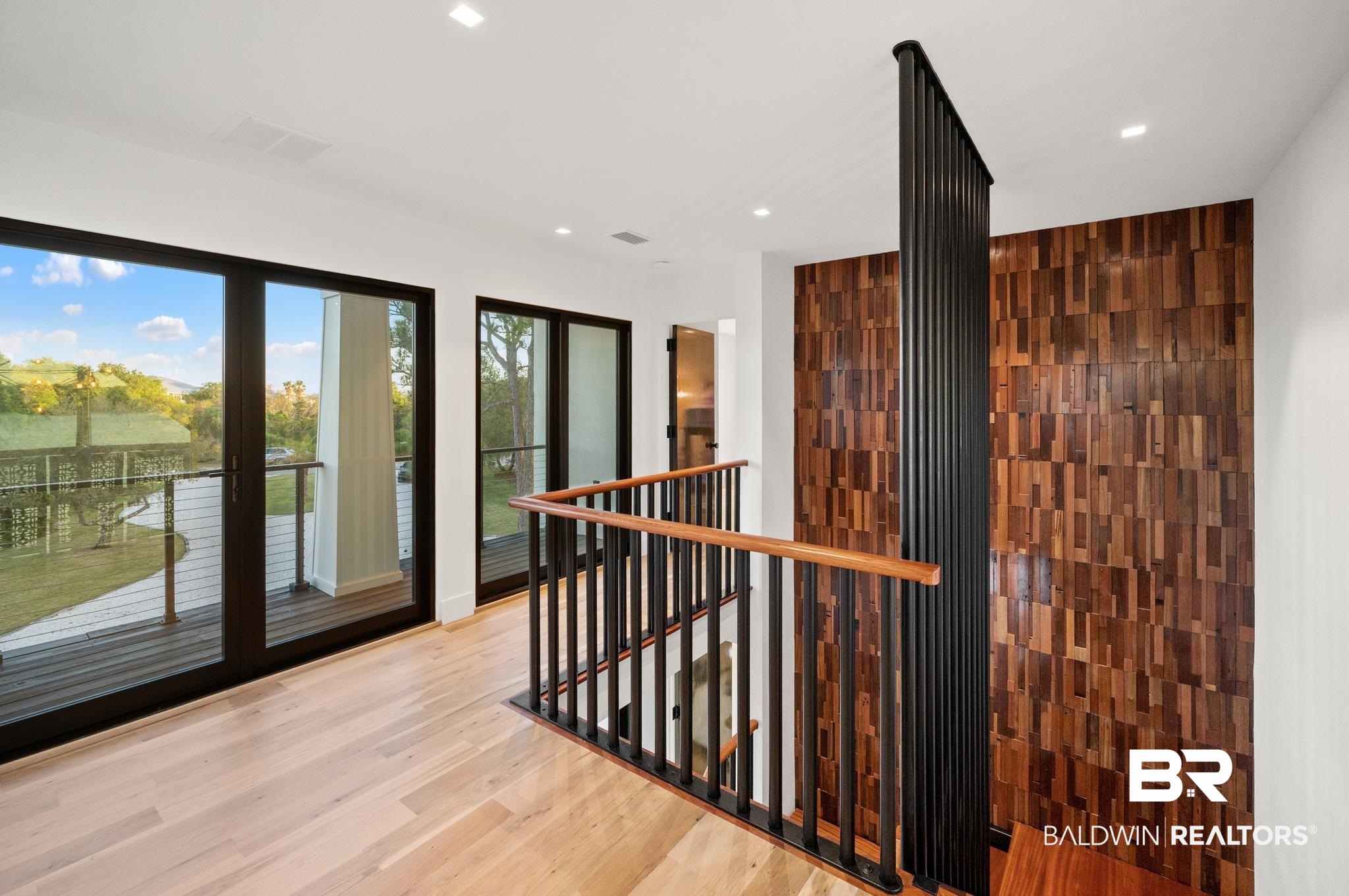 33349 River Road Orange Beach, AL 36561 - Photo 35 of 61 Upper-level hallway featuring light wood-finish flooring, recessed lighting, and a textured wood-panel accent wall