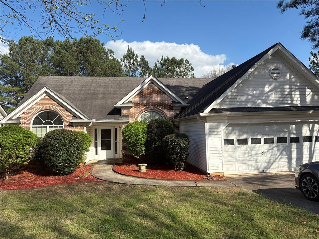 5975 Hillvale Trail Lithonia, GA 30058 - Photo 1 of 10 a front view of a house with a yard and garage