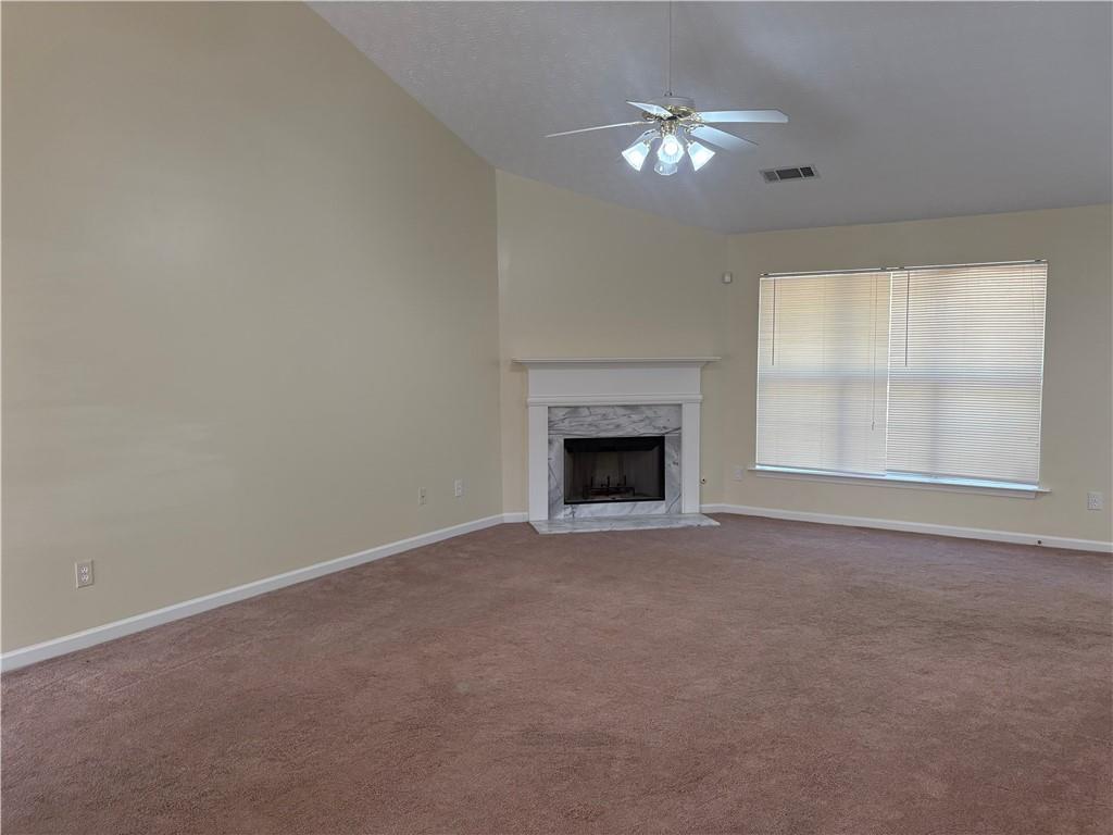5975 Hillvale Trail Lithonia, GA 30058 - Photo 9 of 10 an empty room with chandelier fan and windows