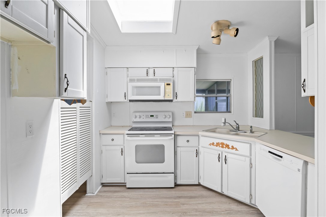 15550 Burnt Store Road, Unit 229 Punta Gorda, FL 33955 - Photo 13 of 41 a kitchen with white cabinets and white appliances