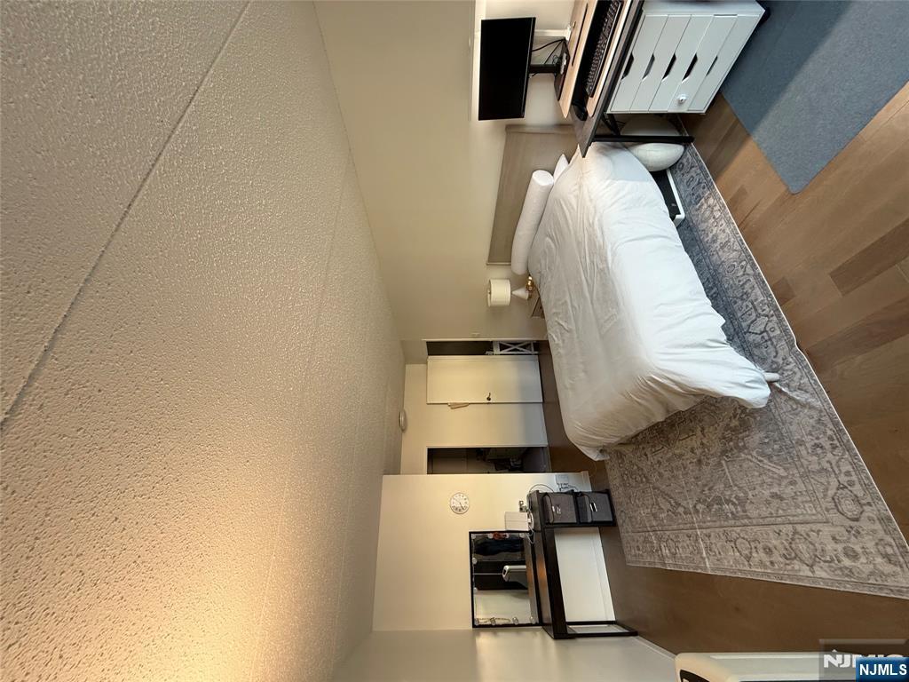 1055 River Road, Unit 504 Edgewater, NJ 07020 - Photo 11 of 17 a bedroom with a bed and a tv on table