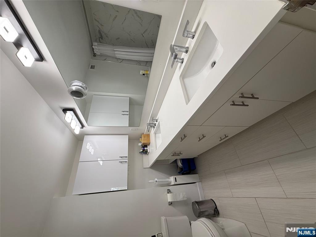 1055 River Road, Unit 504 Edgewater, NJ 07020 - Photo 12 of 17 a bathroom with a sink double vanity and a mirror