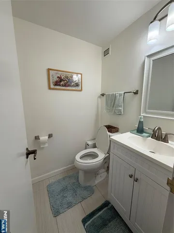 a bathroom with a granite countertop toilet and a sink
