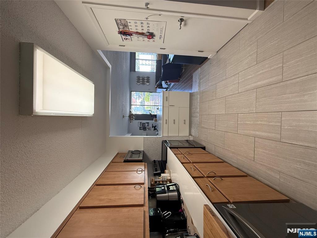 1055 River Road, Unit 504 Edgewater, NJ 07020 - Photo 5 of 17 a large kitchen with cabinets wooden floor and stainless steel appliances