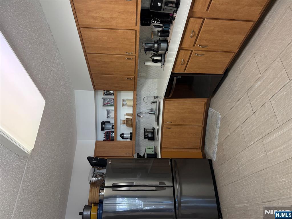 1055 River Road, Unit 504 Edgewater, NJ 07020 - Photo 6 of 17 a kitchen with a sink a refrigerator and cabinets