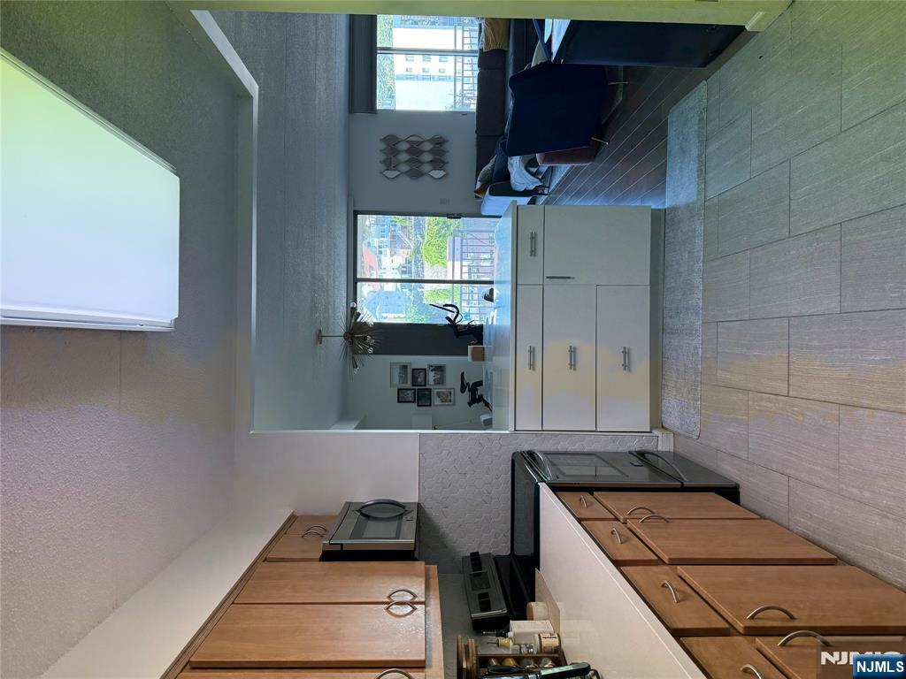 1055 River Road, Unit 504 Edgewater, NJ 07020 - Photo 7 of 17 a kitchen with a stove top oven sink and cabinets