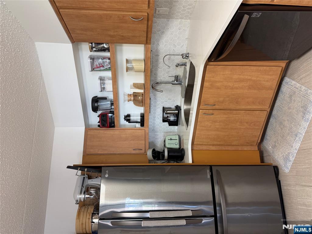 1055 River Road, Unit 504 Edgewater, NJ 07020 - Photo 8 of 17 a kitchen with stainless steel appliances granite countertop a refrigerator and a sink