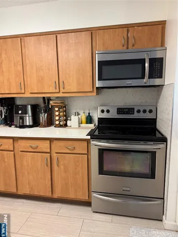 a kitchen with stainless steel appliances granite countertop a stove microwave and cabinets