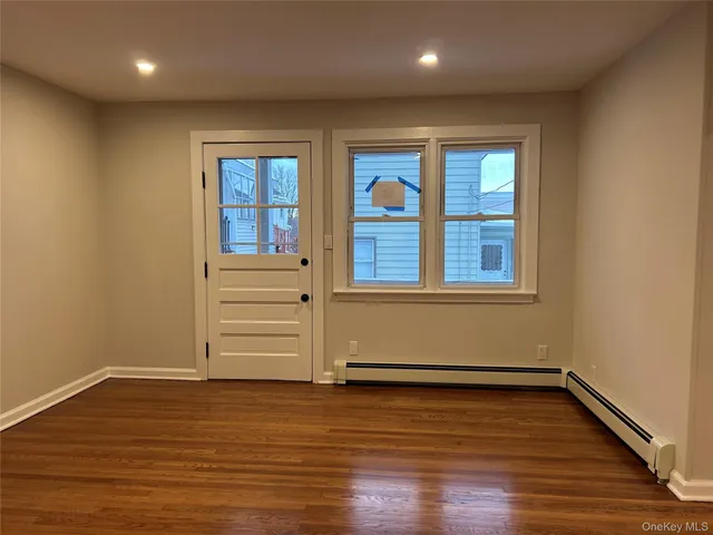 wooden floor in an empty room with a window