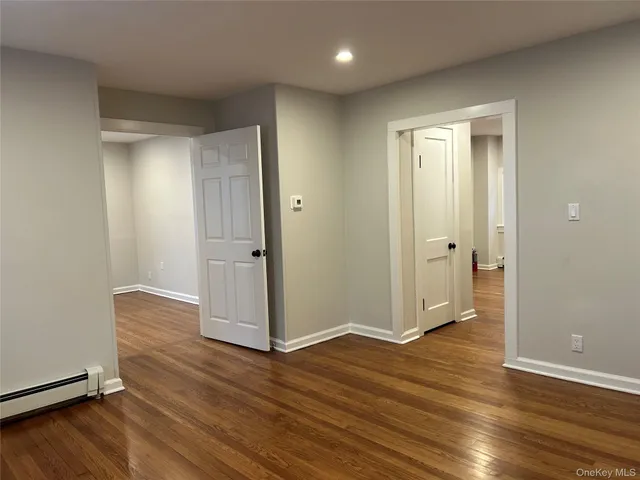 an empty room with wooden floor and entrance