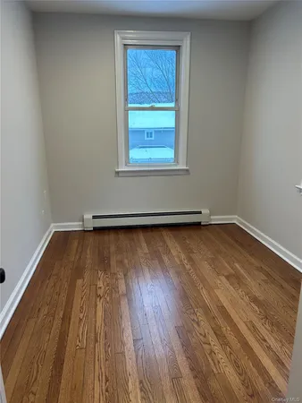 a view of a room with wooden floor and window