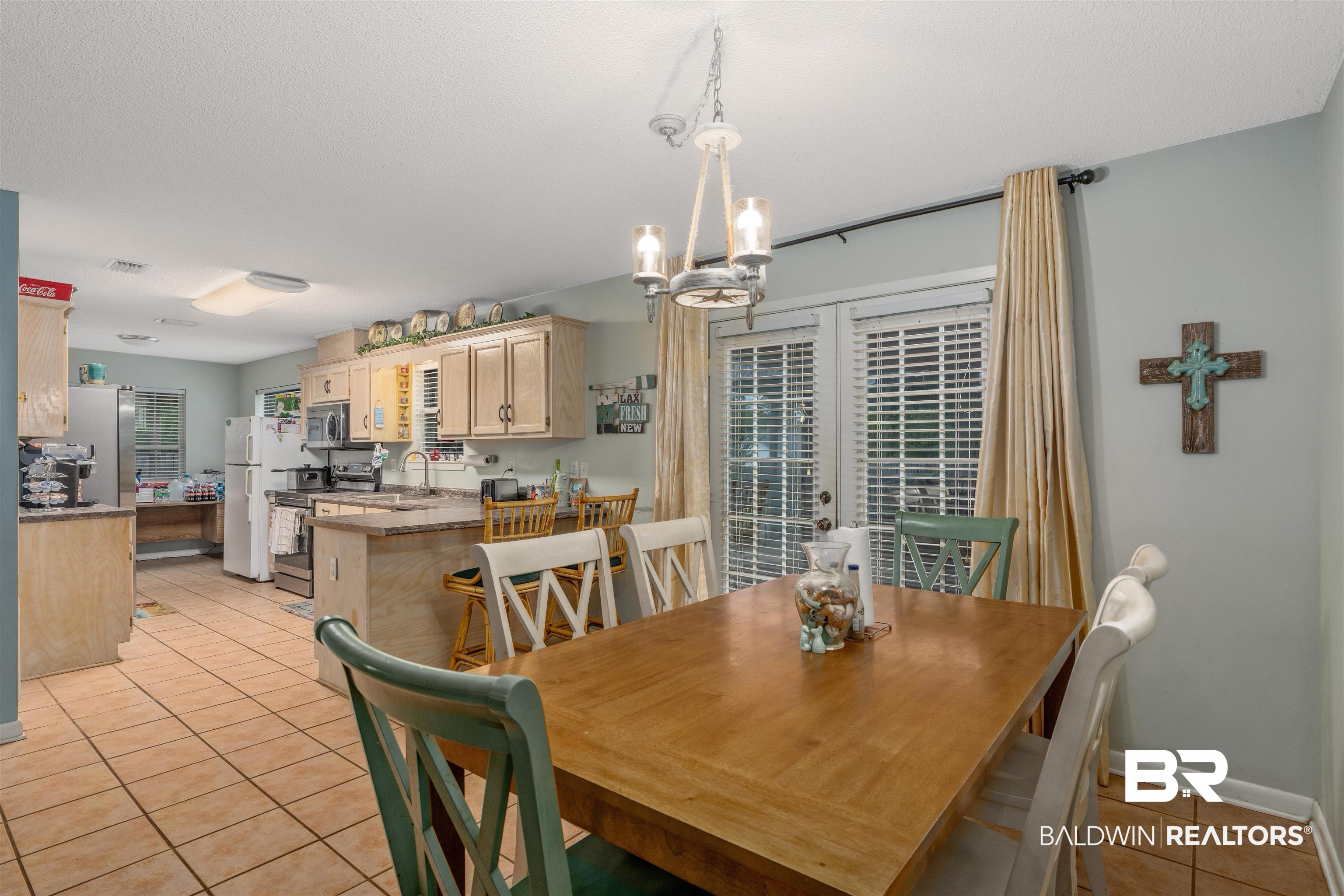 23186 Pecan Street Robertsdale, AL 36567 - Photo 4 of 36 Dining area featuring light tile patterned flooring, a chandelier, and french doors