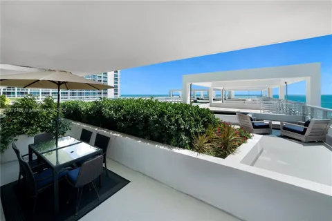 a roof deck with couches and potted plants with sky view