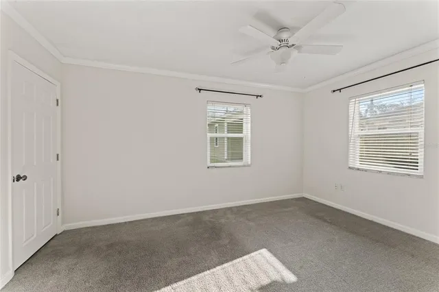 an empty room with a window and a ceiling fan