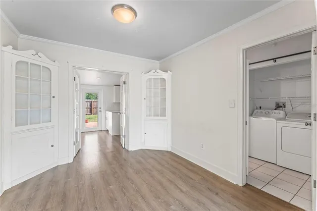 a view of a hallway with wooden floor and a bathroom