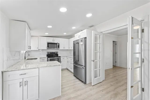 a kitchen with a refrigerator a sink and cabinets