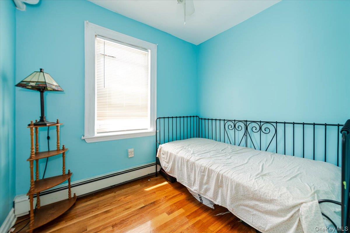 137-27 Thurston Street Queens, NY 11413 - Photo 11 of 19 Bedroom with wood finished floors and a baseboard radiator