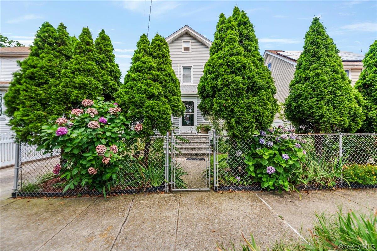 137-27 Thurston Street Queens, NY 11413 - Photo 18 of 19 View of property hidden behind natural elements with a gate and a fenced front yard