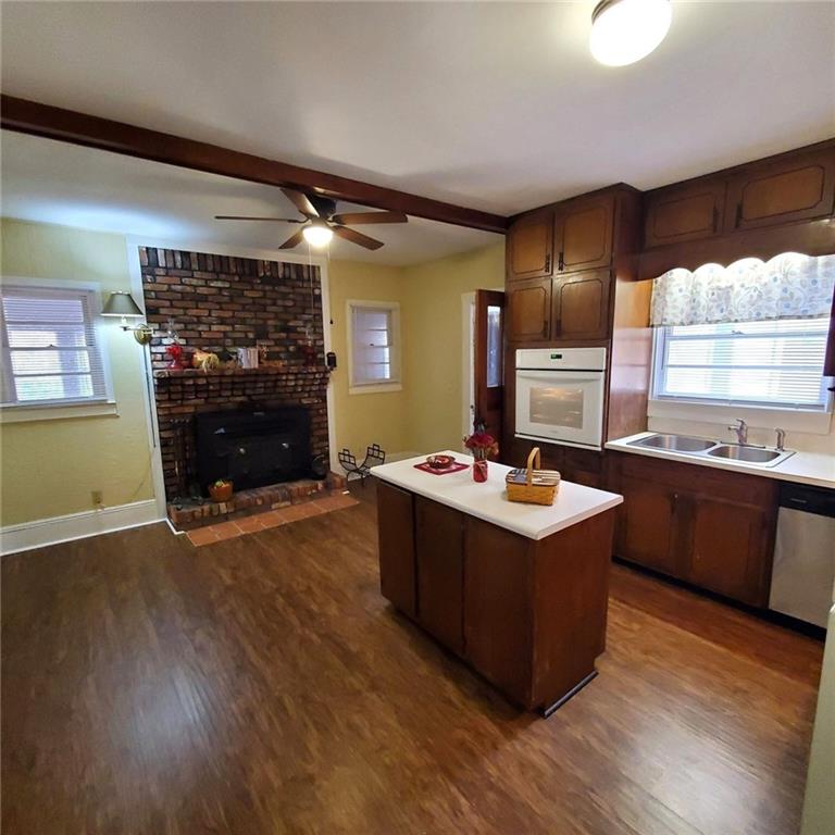 7025 Rico Road Chattahoochee Hills, GA 30268 - Photo 12 of 51 a living room with stainless steel appliances kitchen island hardwood floor and a fireplace