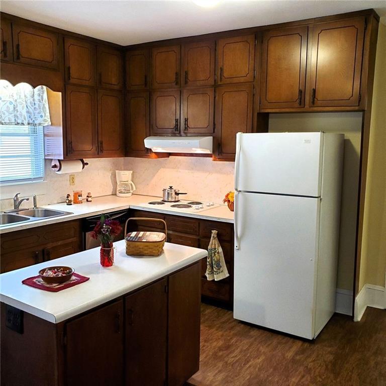 7025 Rico Road Chattahoochee Hills, GA 30268 - Photo 15 of 51 a kitchen with a sink a refrigerator and a stove