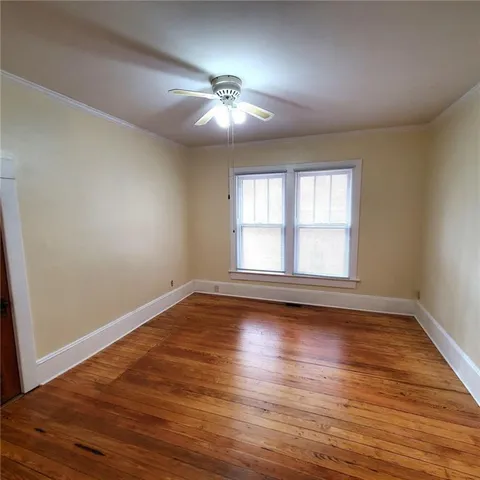 an empty room with wooden floor and window