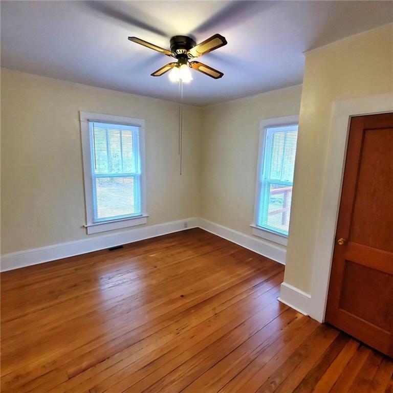 7025 Rico Road Chattahoochee Hills, GA 30268 - Photo 30 of 51 an empty room with wooden floor and windows