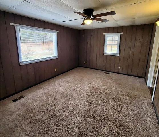 an empty room with windows and cabinet