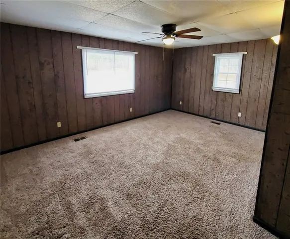 an empty room with windows cabinet and mirror