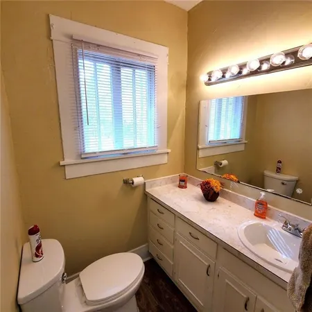 a bathroom with a toilet a sink and a window
