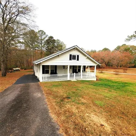 a view of a house with a yard and sitting area