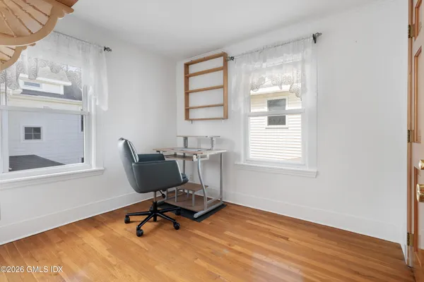 a view of a workspace with furniture and a window