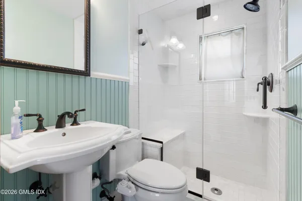 a bathroom with a sink a toilet and shower